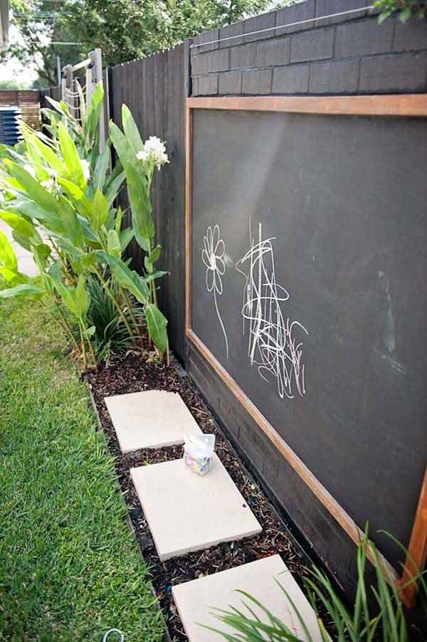 Mount a chalk-painted board to the fence so kids can unleash their creativity outdoors.