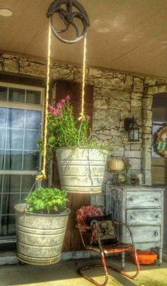 Cast iron pulley with buckets as pot holders for flowering plants